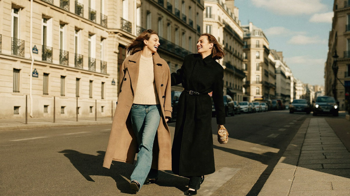 Deux amies en longs manteaux marchant dans une rue de Paris